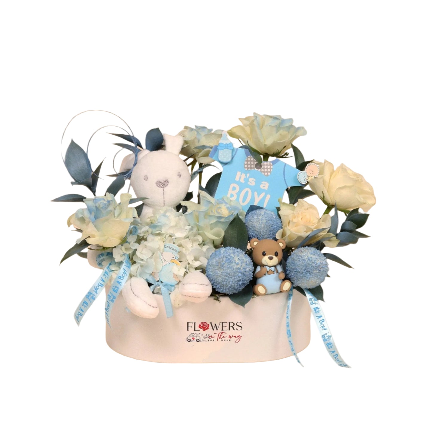 Gentle Arrival is a luxurious baby boy floral box designed with soft elegance and modern charm. Set in a white leather box, it features a beautiful mix of white roses and blue pingpong blooms, delicately complemented by adorable baby boy accessories.
At its heart sits a small white teddy bear, adding a warm and loving touch.
Perfect as a refined newborn gift or as a centerpiece for a stylish baby shower. Handcrafted with fresh blooms and available for same-day delivery in Dubai.