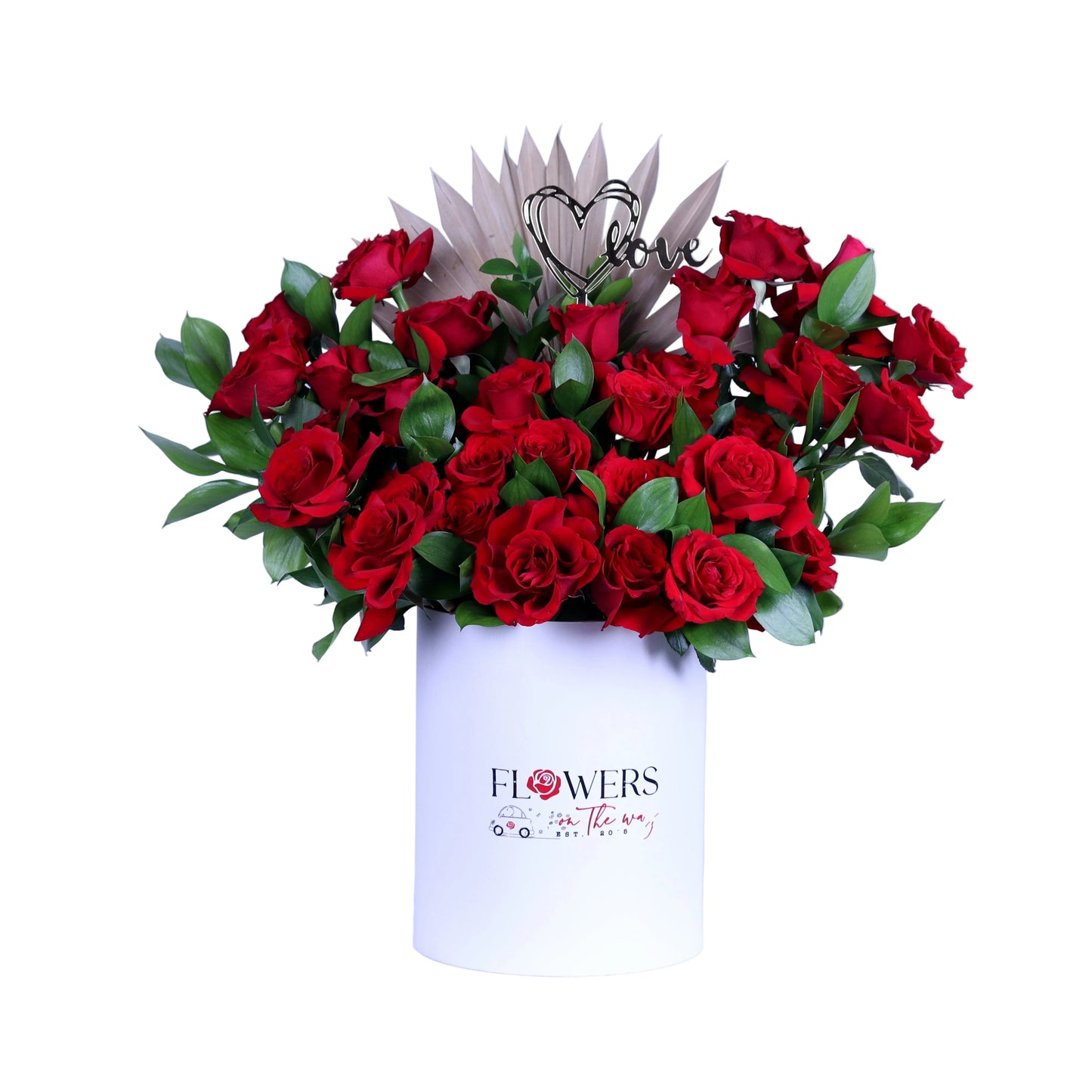 Delight your loved one with the “Pure Romance” Red Roses Arrangement, featuring vibrant red roses beautifully accented with fresh ruscus leaves and a charming acrylic heart, elegantly presented in a white round box. Perfect for Valentine’s Day, anniversaries, birthdays, or intimate romantic gestures, this luxurious bouquet conveys elegance, passion, and heartfelt emotion in every detail.