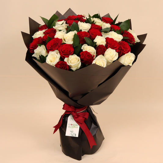 
Classic Love is a luxurious bouquet of 50 fresh roses in red and white, beautifully arranged to reflect both passion and purity. Wrapped in elegant black paper, the contrast enhances the bold colors and gives it a timeless, sophisticated look.
Perfect for romantic gestures, anniversaries, or heartfelt expressions of love and appreciation. Handcrafted with premium blooms and available for same-day delivery in Dubai.