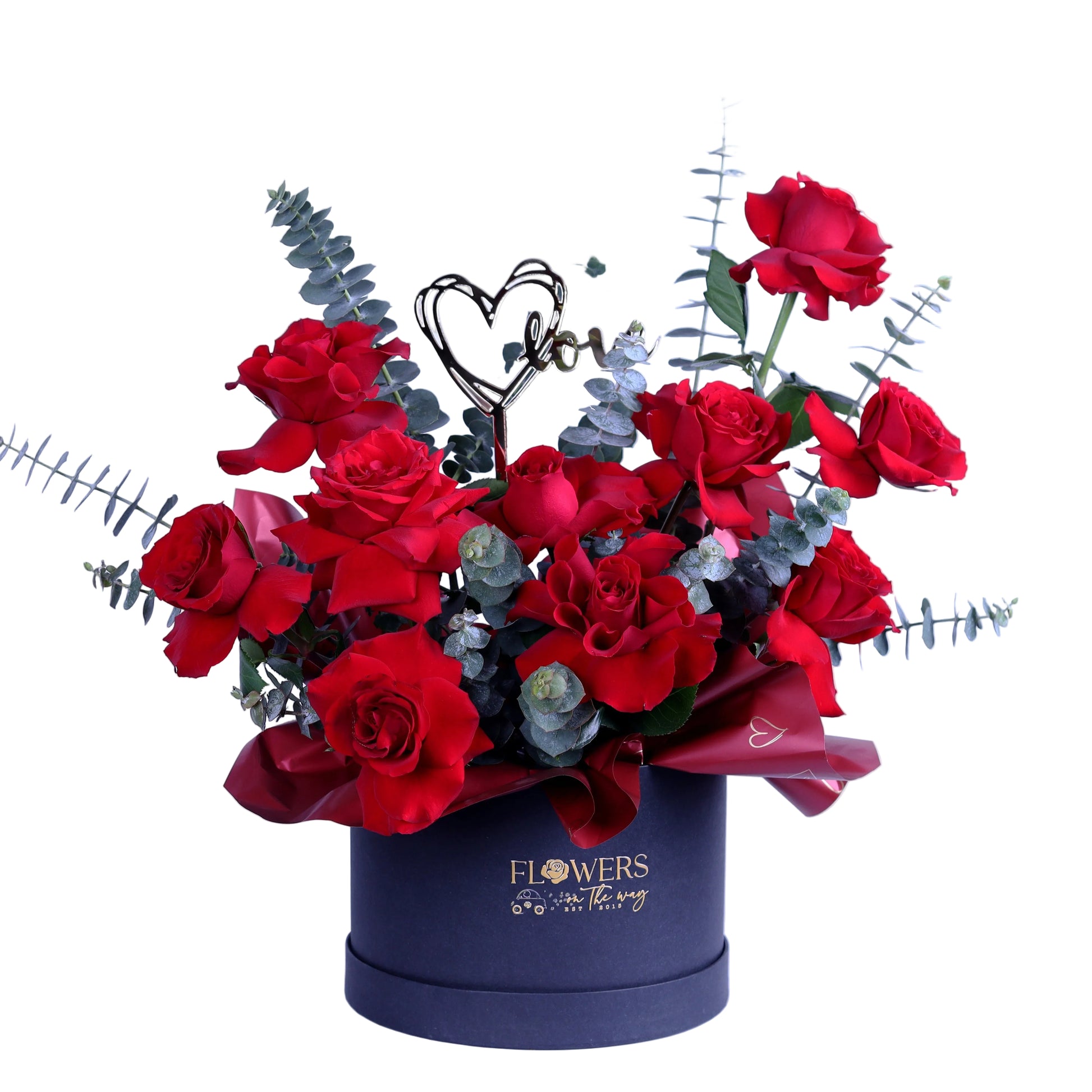 Create a lasting impression with this Romantic Red Roses Box, featuring premium red roses elegantly arranged with fresh eucalyptus leaves and finished with a stylish acrylic heart. Presented in a chic small round box, this arrangement is ideal for Valentine’s Day, anniversaries, and meaningful romantic surprises.