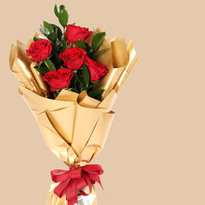 Elegant bouquet of 5 red roses wrapped in golden paper. A perfect romantic gift with fast delivery in Dubai.