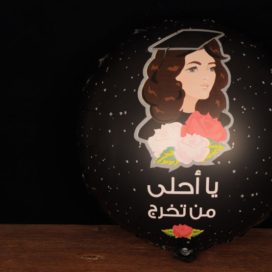 Black graduation balloon with a graduate illustration and Arabic text