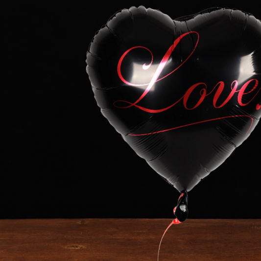 Black heart-shaped balloon reading Love