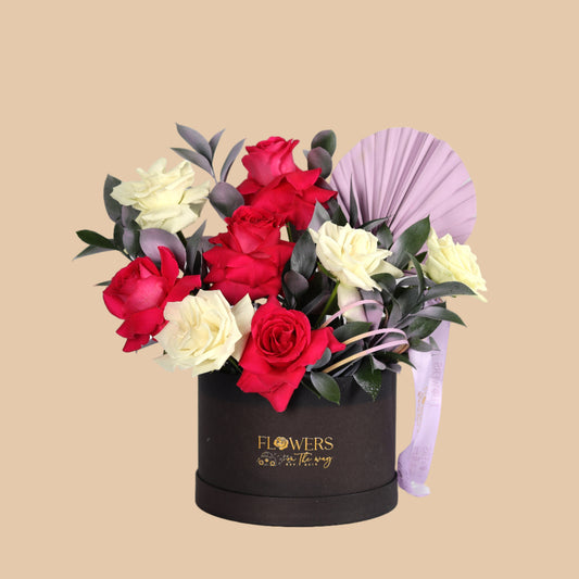 Elegant black box featuring a mix of fuchsia and white flowers with stylish purple accents. A perfect gift for any occasion with fast flower delivery across Dubai.