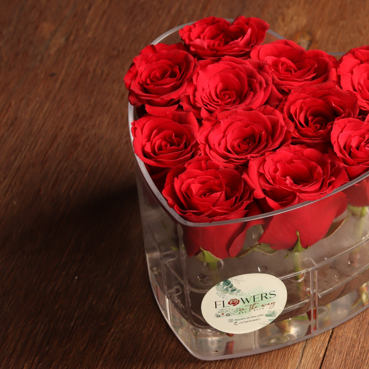 Clear heart-shaped box filled with red roses