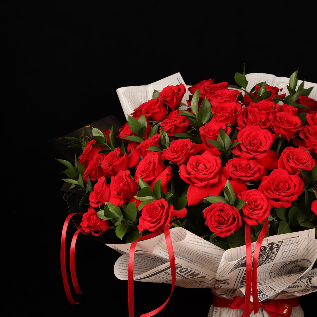Vintage Love Story – 50 red roses with ruscus in newspaper-style paper, alternate view, Valentine's Day flower delivery Dubai