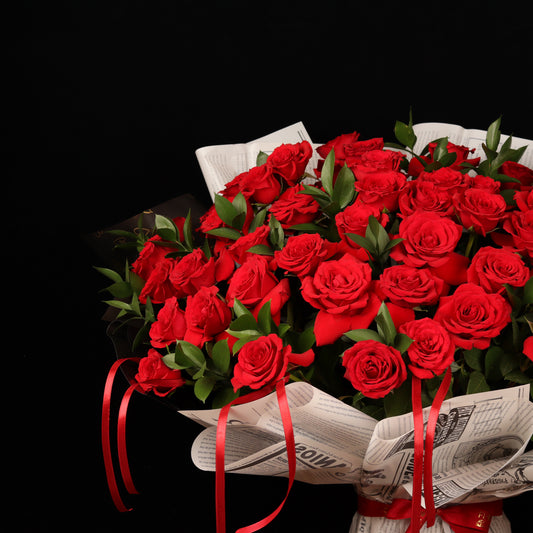 Vintage Love Story – 50 red roses with ruscus in newspaper-style paper, alternate view, Valentine's Day flower delivery Dubai