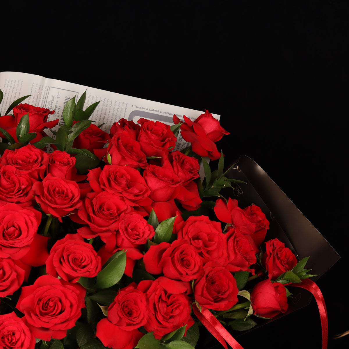 Vintage Love Story – 50 red roses with ruscus in newspaper-style paper, alternate view, Valentine's Day flower delivery Dubai