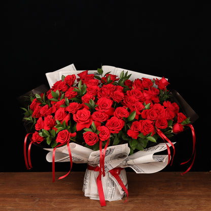 Vintage Love Story – 50 red roses with ruscus in newspaper-style paper, Valentine's Day flower delivery Dubai