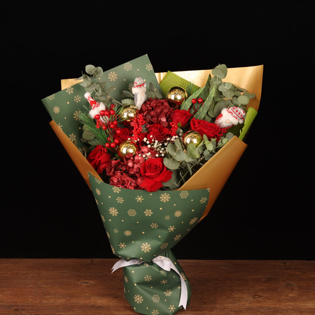 Golden Snowflake - red roses and crimson blooms Christmas bouquet in green snowflake wrapping with gold foil, Christmas flower delivery Dubai