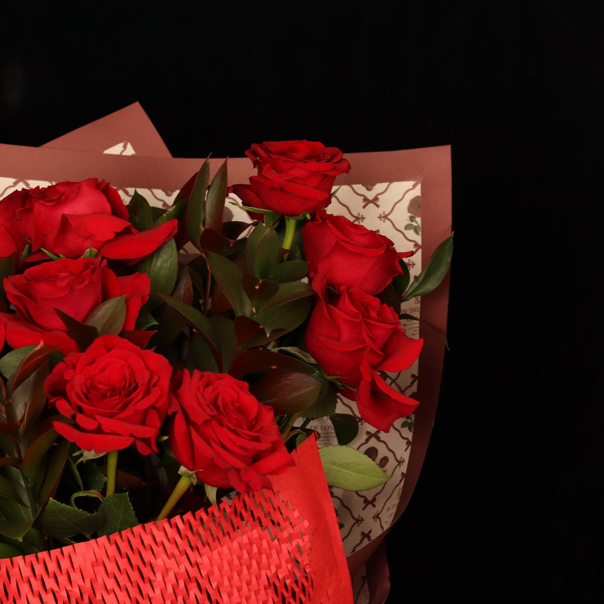In the Name of Love Bouquet – close-up of red roses with ruscus and vintage In the Name of Love paper