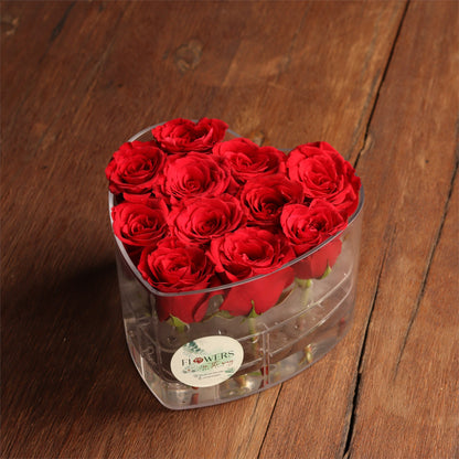 Scarlet roses arranged inside a clear heart-shaped keepsake box