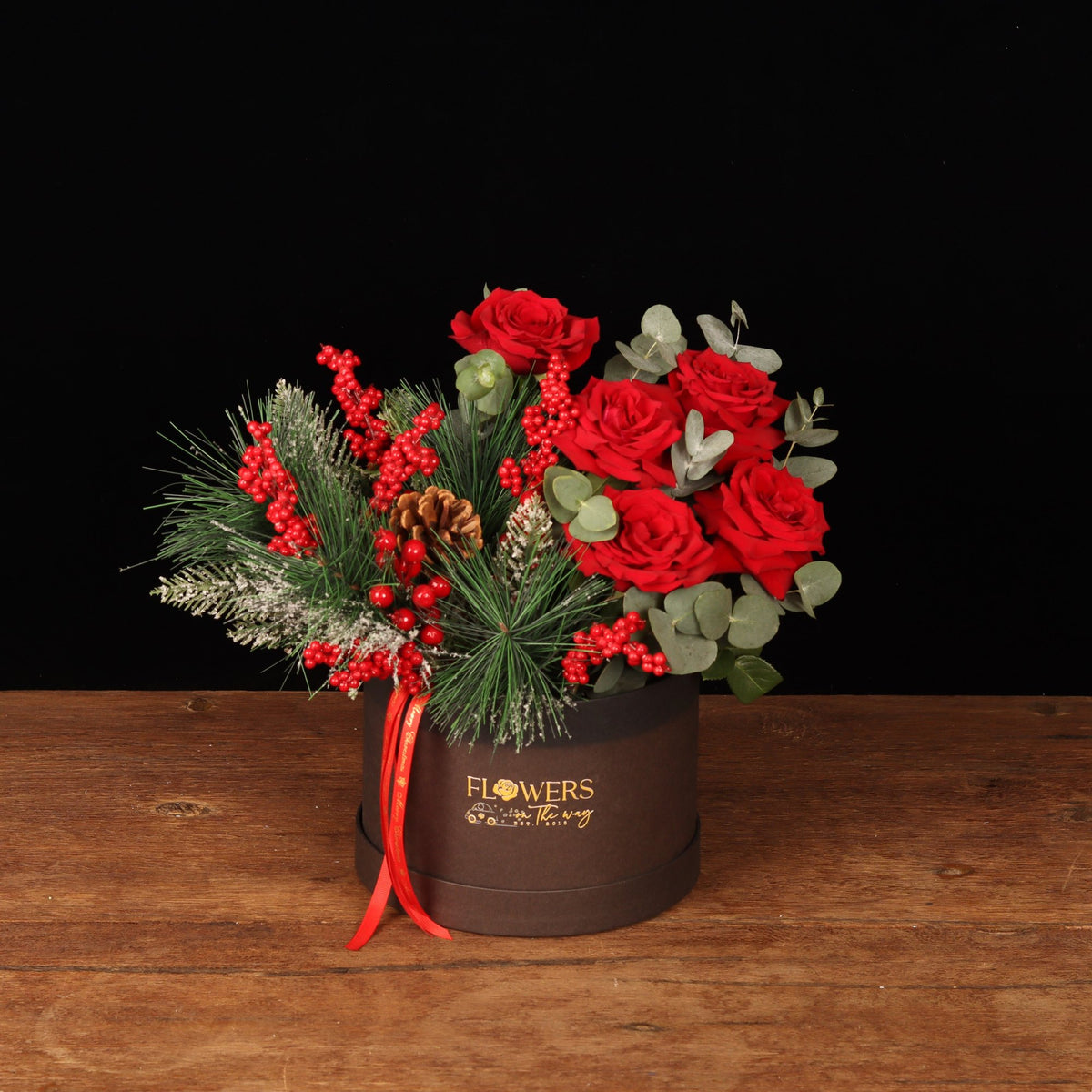 Winterberry Elegance Box - red roses, frosted pine and red berries in a brown round Christmas flower box, flower delivery Dubai